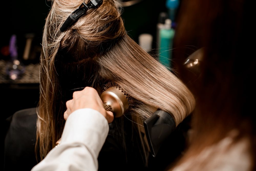 Jeune femme en train de profiter d'un soi Brushing en salon de coiffure